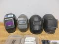 Jackson Auto Darkening Welding Helmet with (3) Older Fixed Shade Helmets and Bin of Tinted and Clear Glass Filler Plates- Auction Item
