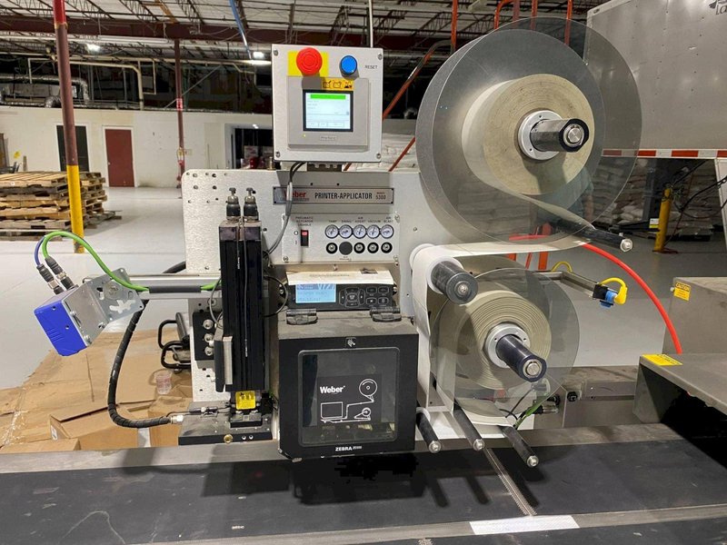 System Packaging 900-24 3B Labeler, 2020 – Weber Box Label Printer/Applicator Model: 5300 L.H. DOM, 1 Pallet of Cold Seal Material Included **Pre-Removal Pricing**