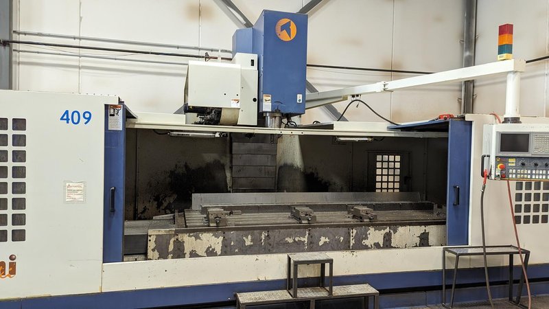 TAKUMI, V32, CNC VERTICAL MACHINING CENTRE, 10,000 RPM SPINDLE, TRAVELS (X,Y,Z): 3200 MM X 1066MM X 750 MM (126&quot; X 42&quot; X 30), DISTANCE FROM NOSE TO SPINDLE:  200MM TO 950MM, DISTANCE FROM SPINDLE NOSE TO THE Z-AXIS GUIDEWAY: 1120MM, T-SLOT TABLE SIZE: 3200MM X 1025MM (126&quot; X 40&quot;), MAX TABLE LOAD, 4500 KG (9,920 LBS), 32 TOOL ATC, TABLE SIZE: 42&quot; X 130&quot;, CAT 50, 30 KW, SPINDLE FLOOD AND THROUGH COOLANT, AIR BLAST, COOLANT FILTER SYSTEM, CHIP WASH DOWN SYSTEM, CHILLED BALL SCREW AND SPINDLE, 4-AXIS CAPABLE,  LEFT AND RIGHT CHIP CONVEYOR,  MITSUBISHI, MEDLAS 60S, CNC CONTROL, 2006, 220/3/60 50 AMP, MACHINE WEIGHT:  52.500 LBS. FLOOR SPACE (W, L, H) 295&quot; X 173&quot; X 139.7&quot; (APPROX.), S/N K0133