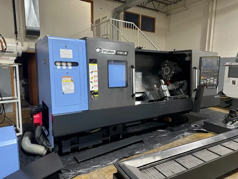 2023 DN SOLUTIONS PUMA 4100LMB CNC Universal Turning Center. Equipped for versatile 2-axis and 3-axis lathing, it features a 15" chuck, 50 HP spindle, and a machining length of 79.8" and with hydraulic open / close steady rest. Perfect for heavy-duty tasks. Fanuc Control, 50HP
