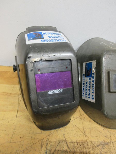 Jackson Auto Darkening Welding Helmet with (3) Older Fixed Shade Helmets and Bin of Tinted and Clear Glass Filler Plates- Auction Item